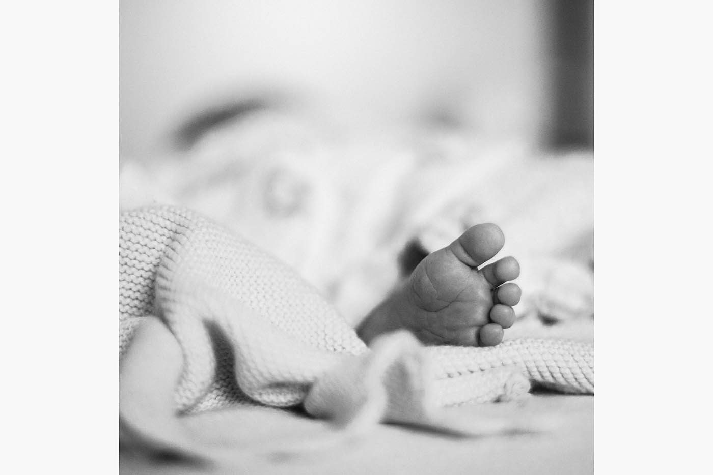 Les petits pieds d'un bébé endormi dépassant de la couverture