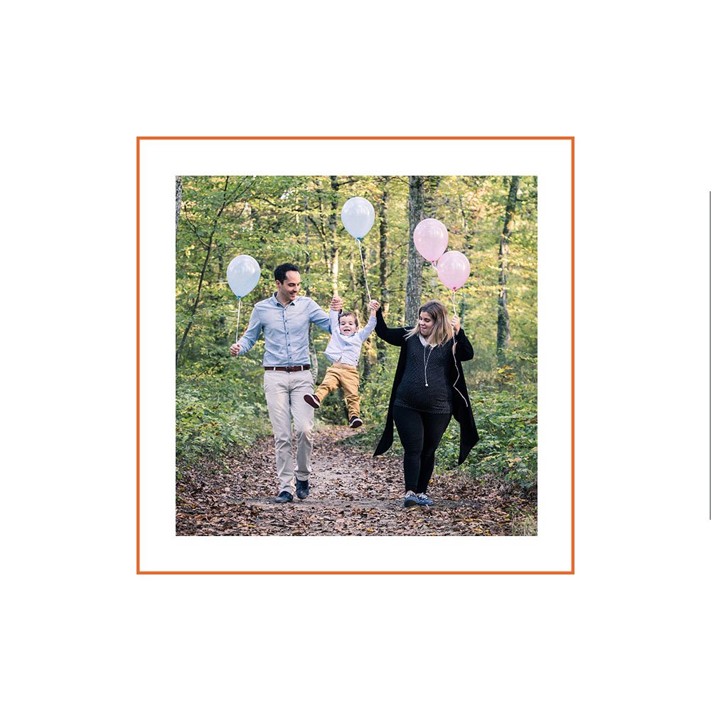 Des ballons colorés pour fêter l'arrivée de sa petite soeur lors d'une promenade en forêt avec ses parents